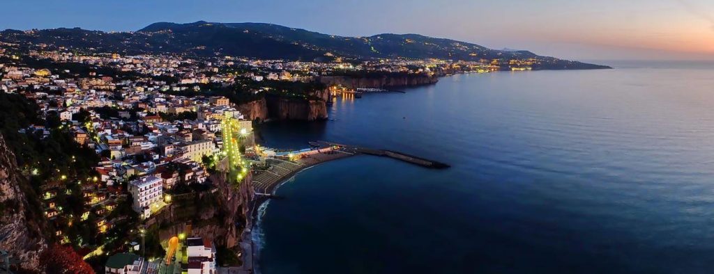 meta coastline sorrento showing massive golden tufa cliffs dropping straight down into the deep blue sea neatly