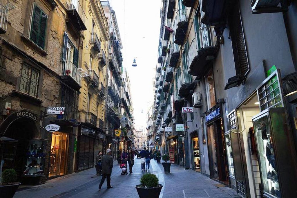 is via chiaia naples worth visiting featuring a narrow historic alleyway lined with elegant balconies smoothly
