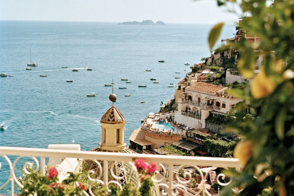 positano from naples ferry arrival photography showing colorful wooden skiffs moored inside the busy cliffside harbor