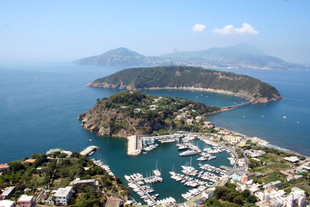 marina di chiaiolella procida photo spots showing traditional wooden boats docked near pastel-colored houses cleanly