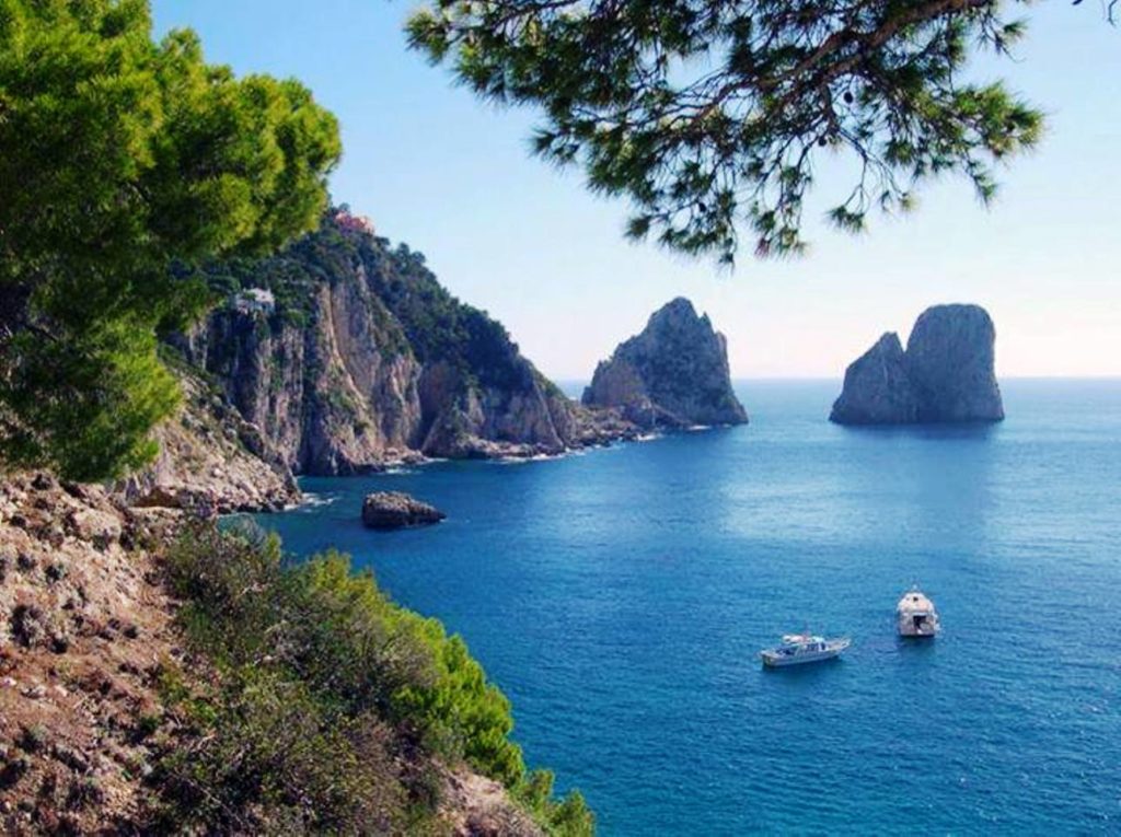 faraglioni capri photo spots showing the massive limestone rocks rising out of the deep turquoise sea cleanly