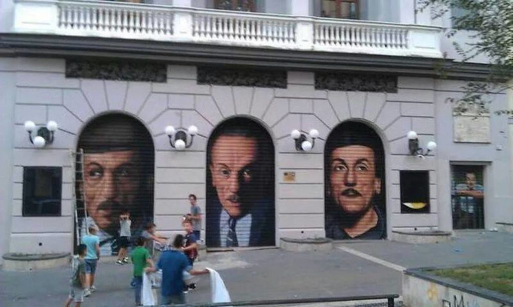 how to photograph street art teatro san ferdinando napoli showcasing the massive realistic mural of Eduardo De Filippo on a public building wall cleanly