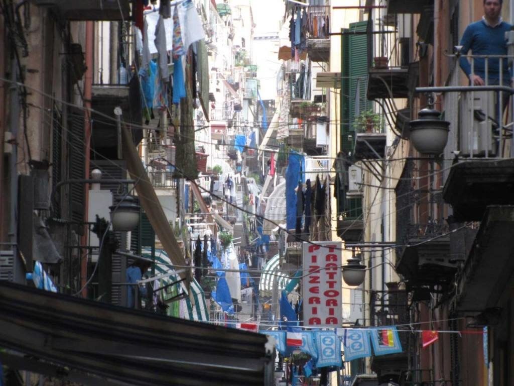 best photo spots in quartieri spagnoli napoli showing a narrow cobblestone alleyway draped with hanging laundry lines cleanly